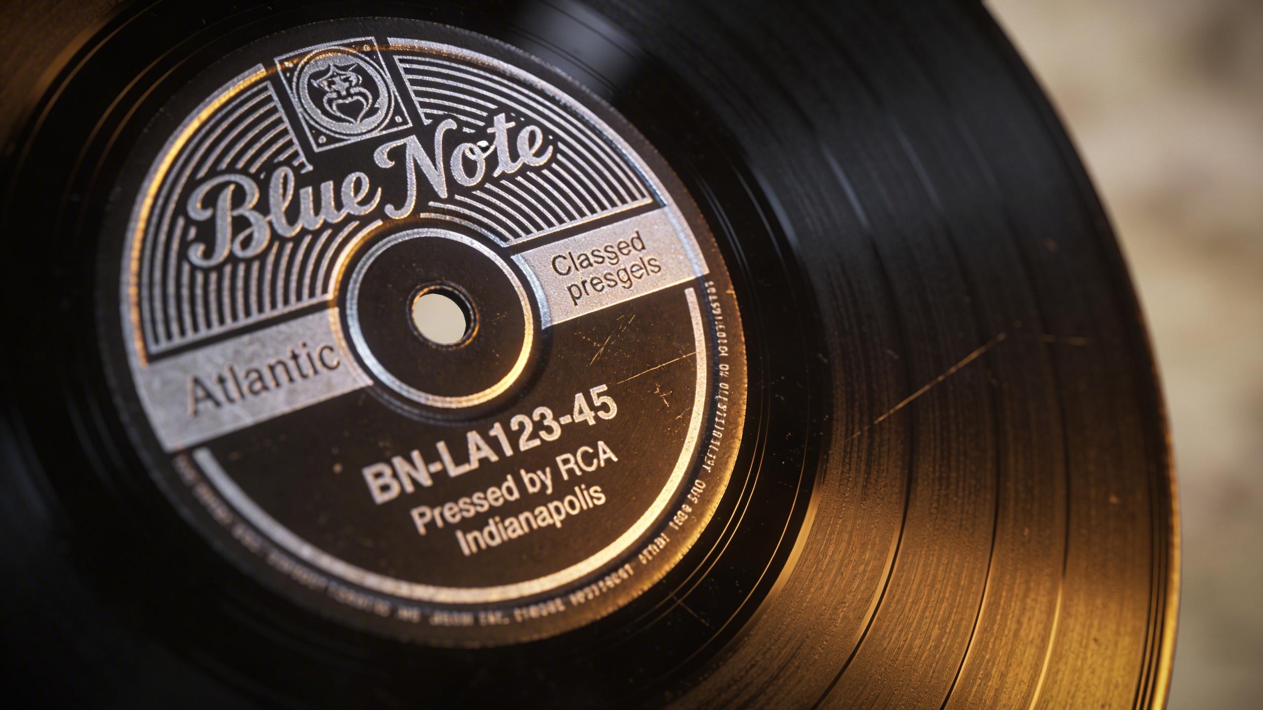 Photorealistic: Detailed macro shot of vinyl record label showing catalog number and pressing plant information, dramatic side lighting highlighting the texture and details, classic album labels like 